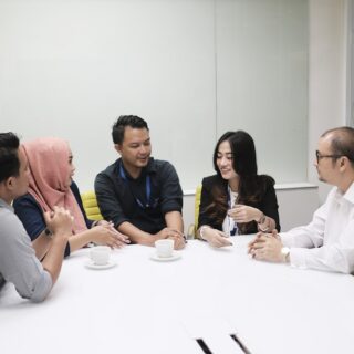 a group of people sitting around a white table