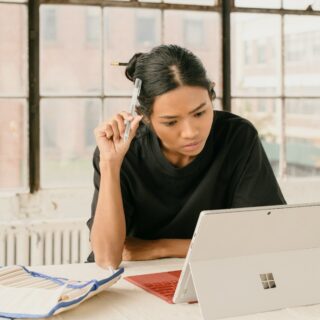 a woman sitting at a table using a laptop computer